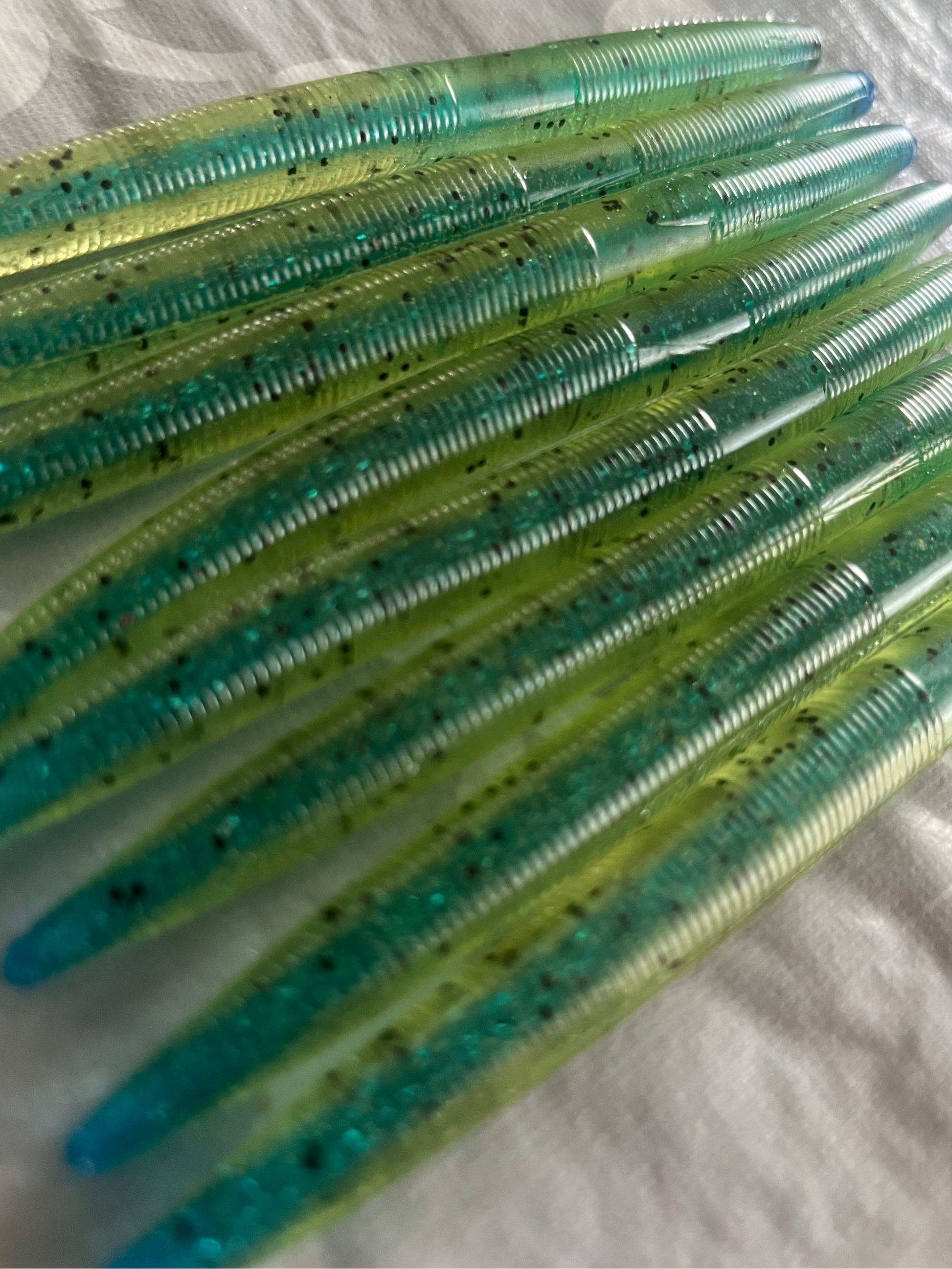 Close-up of green and blue fishing lures on a white background